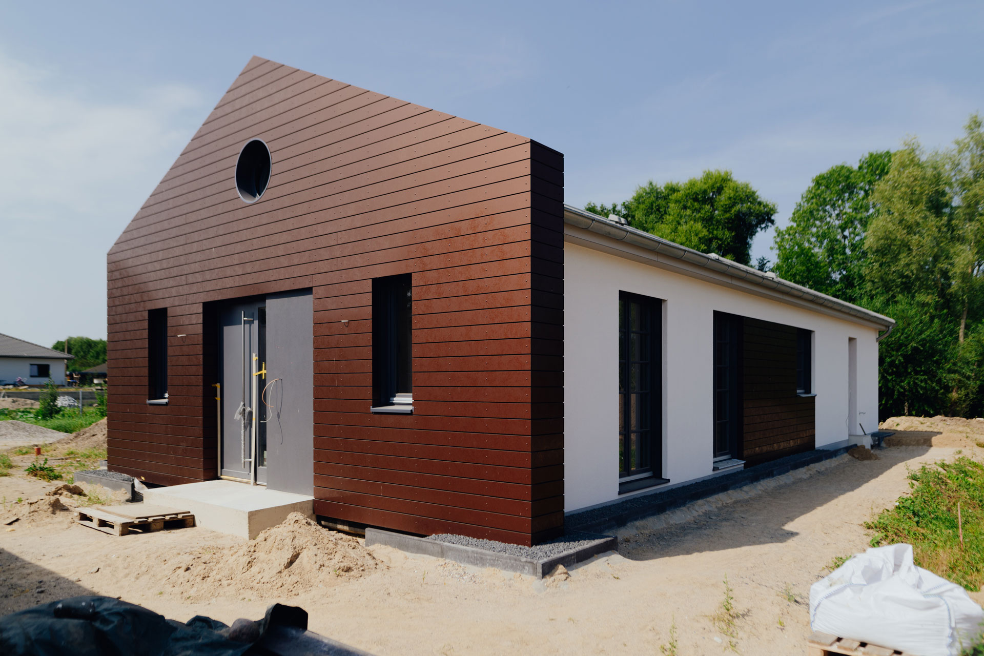 Das gesamte Haus ist hauptsächlich weiß und hat dominante Holzbauakzente. Es ist der Eingangsbereich.