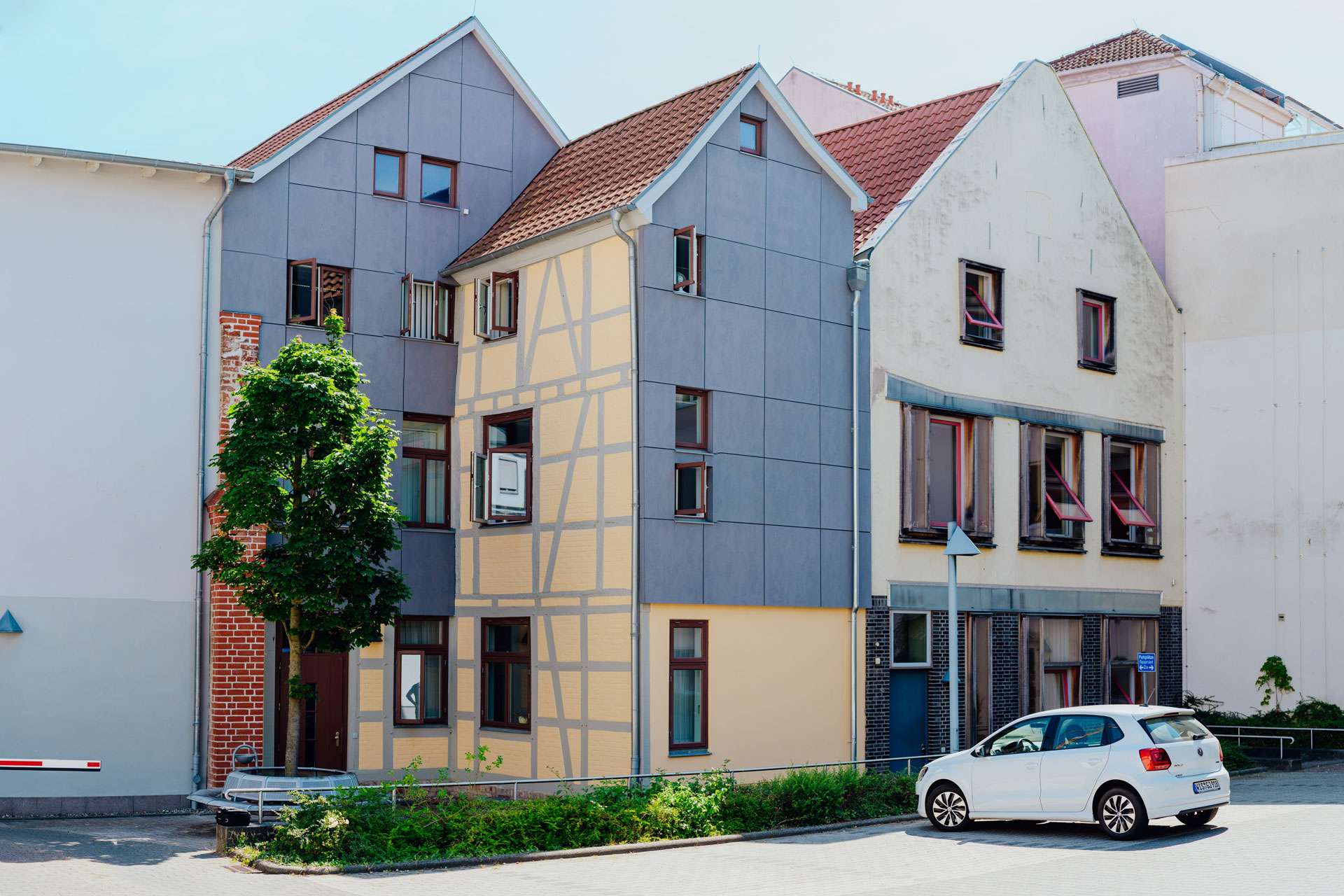 Ein Geschäftshaus in der Altstadt von Wismar hat vier Etagen. Davor parkt ein Auto.