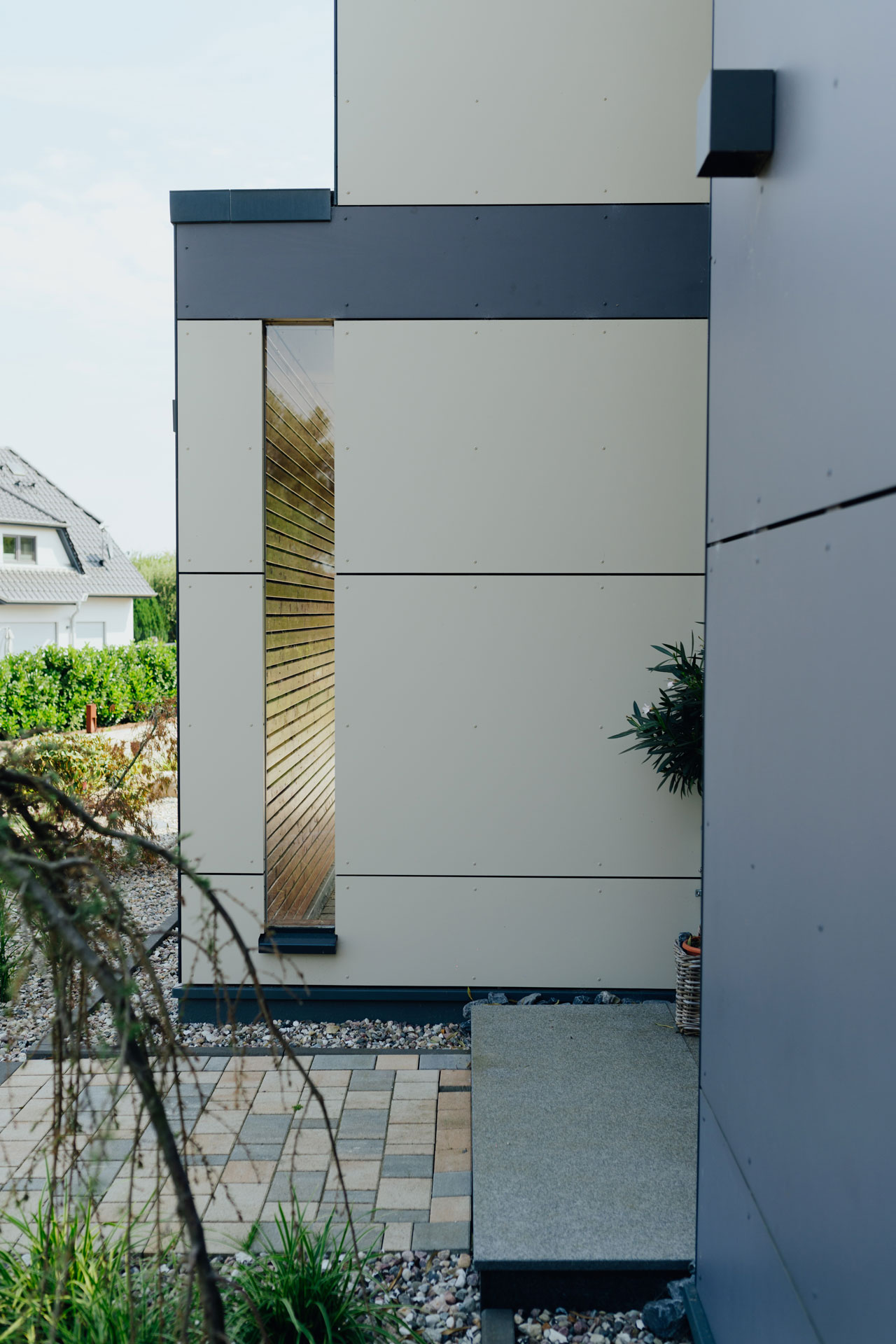 Seitlich am Eingangsbereich ist ein sehr schmales vertikales Fenster.