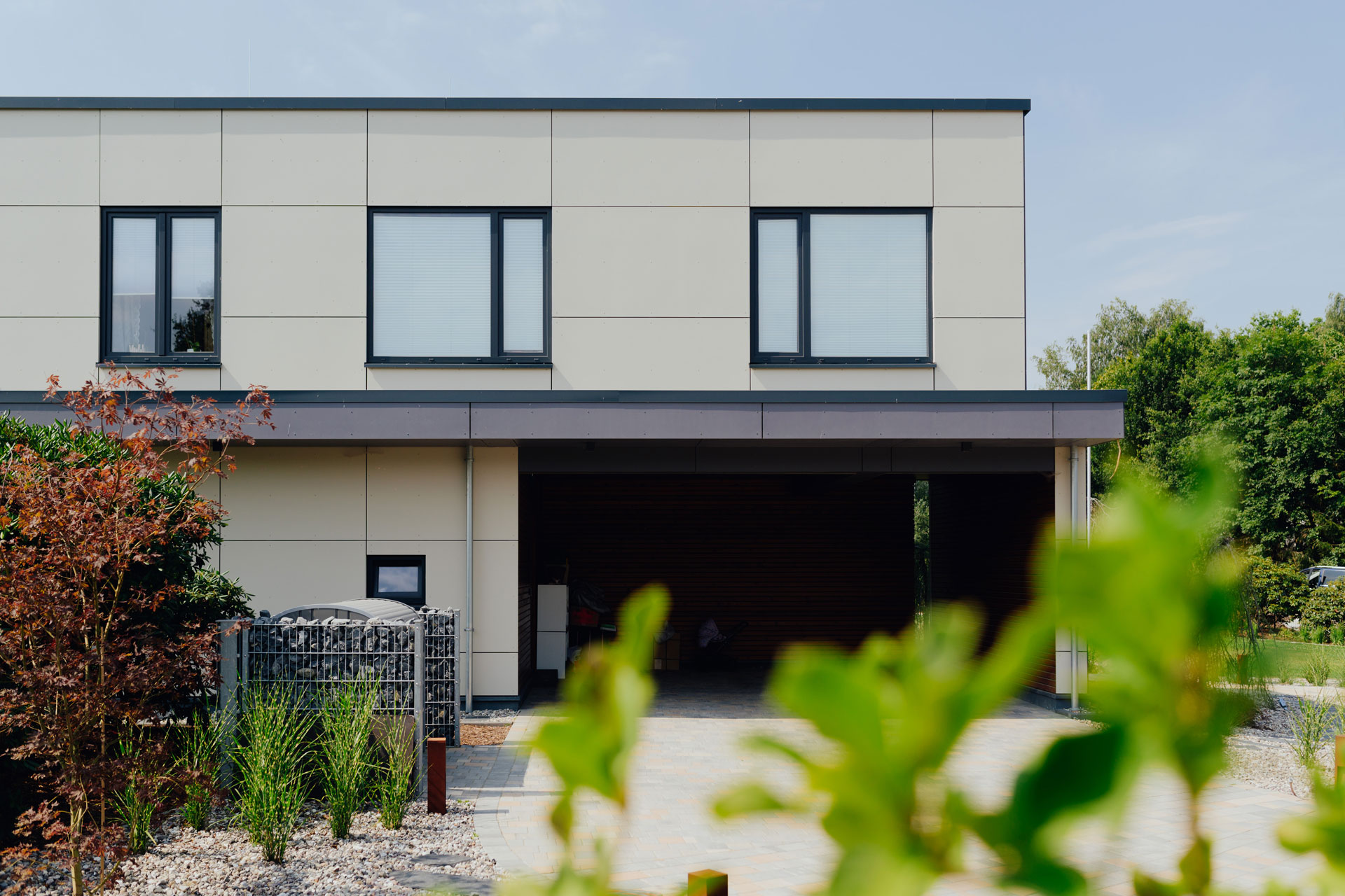 Eine breite Zufahrt führt unter dem Carport des Hauses.
