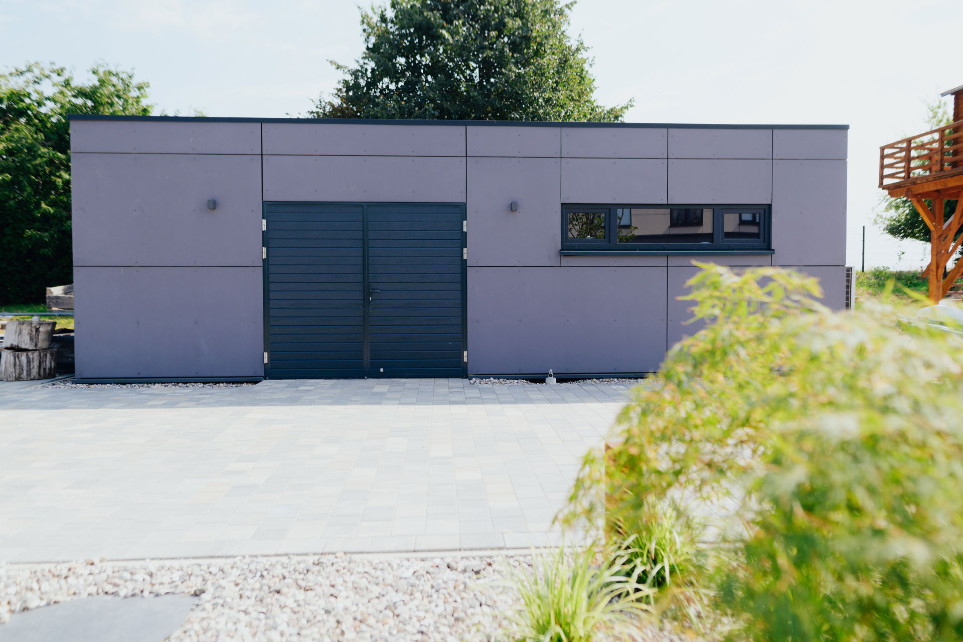 Ein Garagenbau ist außen grau verkleidet.