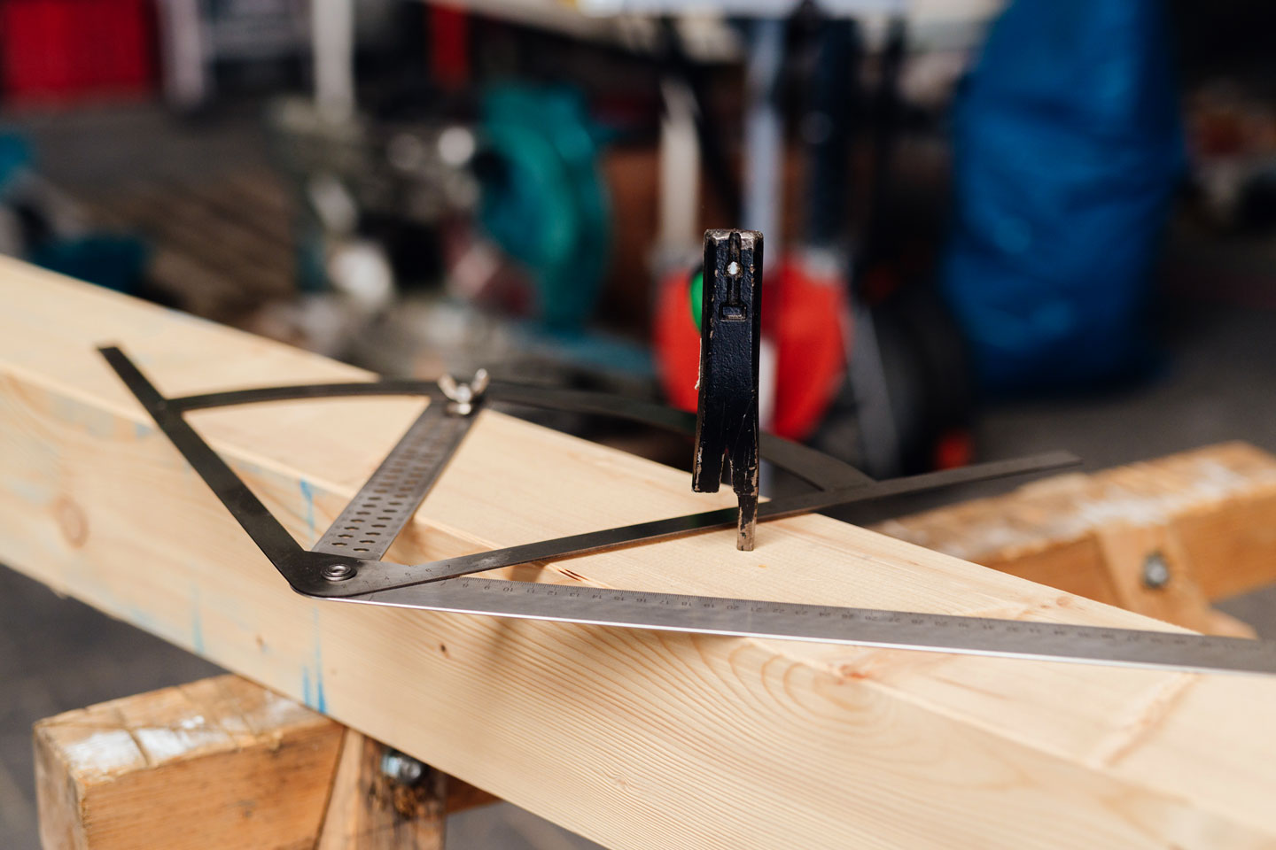 Ein Winkelmesser liegt auf einem Holzbalken.