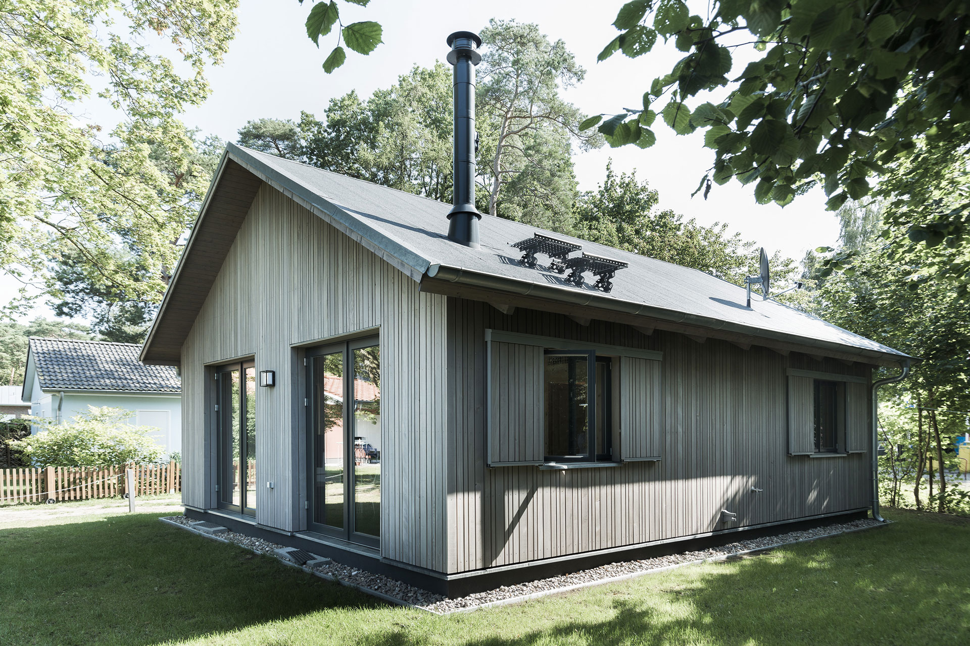 Ein Holzferienhaus steht im Grünen.