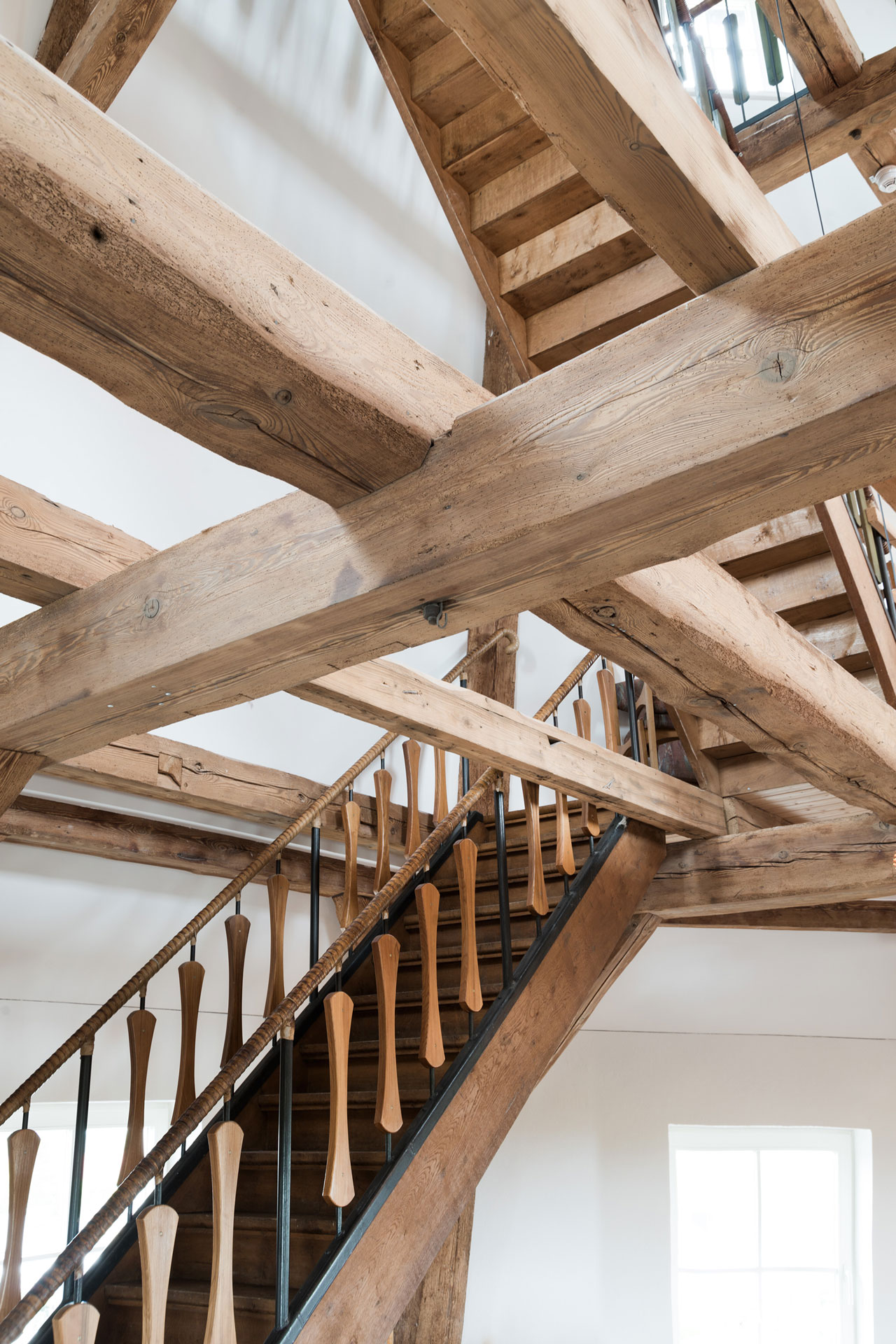 Viele sehr massive Holzbalken sind teils gekreuzt durch den Raum verbaut.