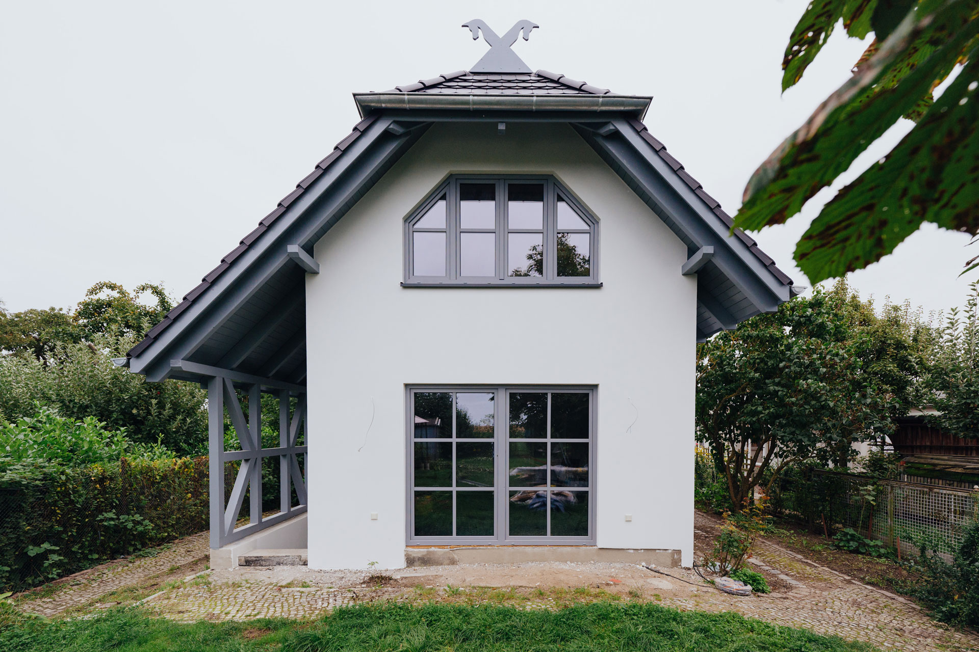Ein Ferienhaus einen typischen Giebelschmuck. Es sind zwei gekreuzte Pferdeköpfe.