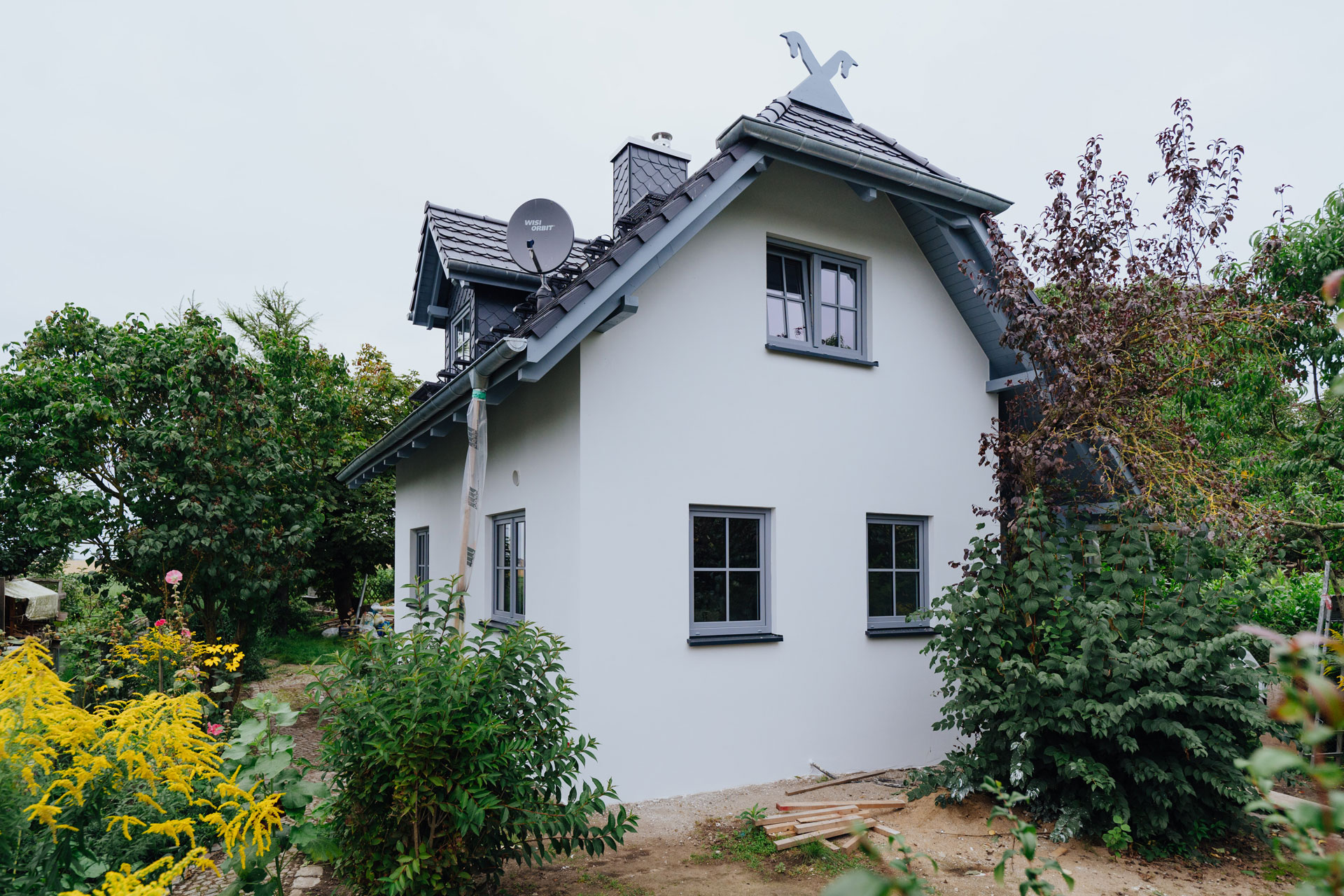 Das Ferienhaus ist von viel Natur umgeben – Büsche, Bäume und Blumen.