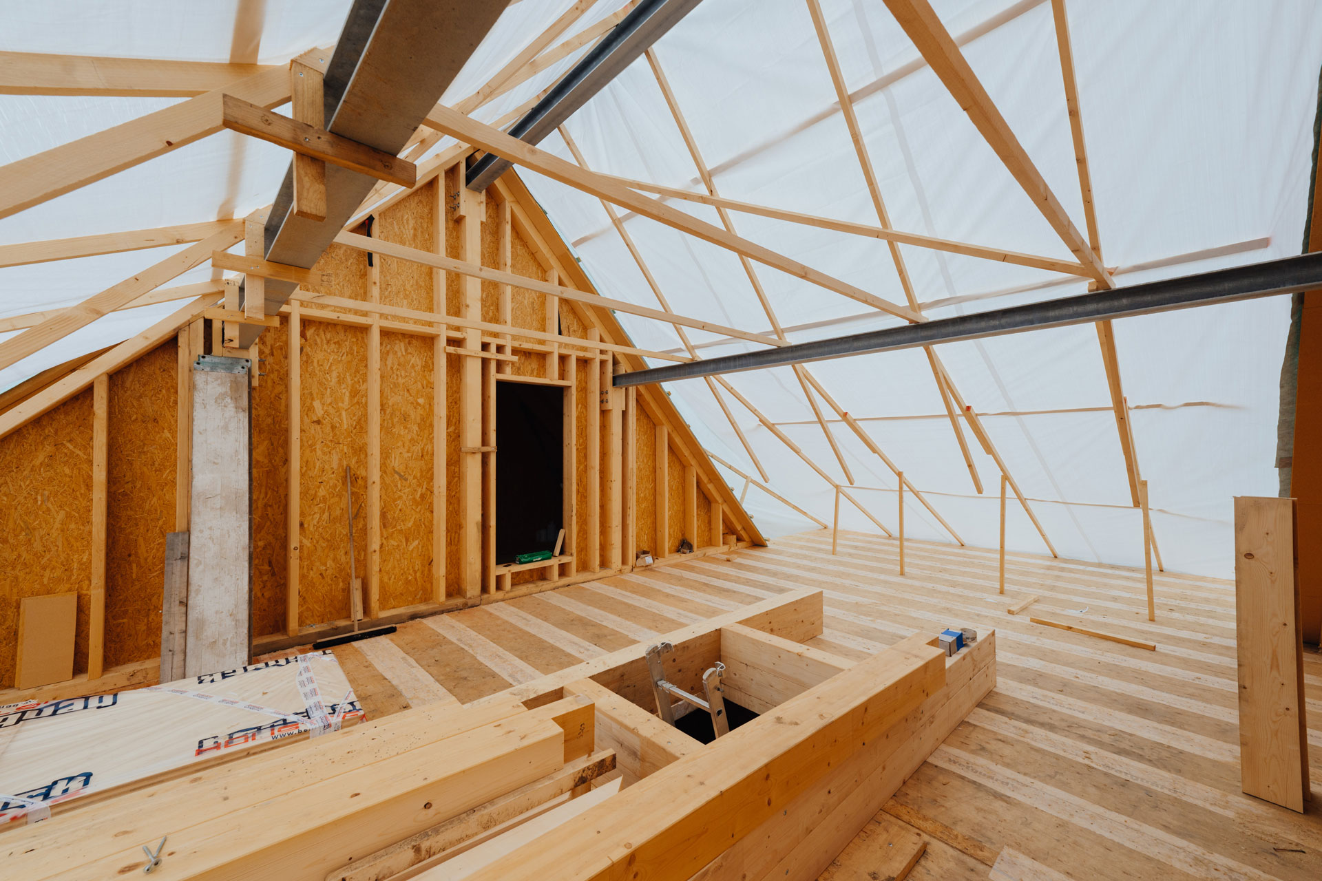 Die Holzkonstruktion des Dachstuhls ist mit Planen bedeckt.