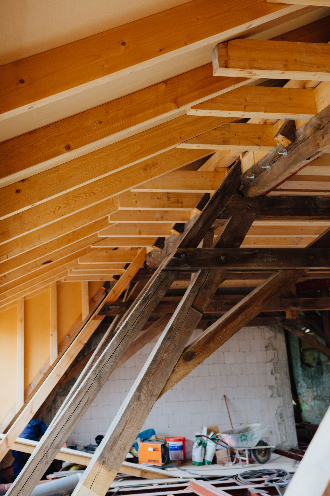 Frische Holzbalken und alte sind im Dachstuhl verbaut.