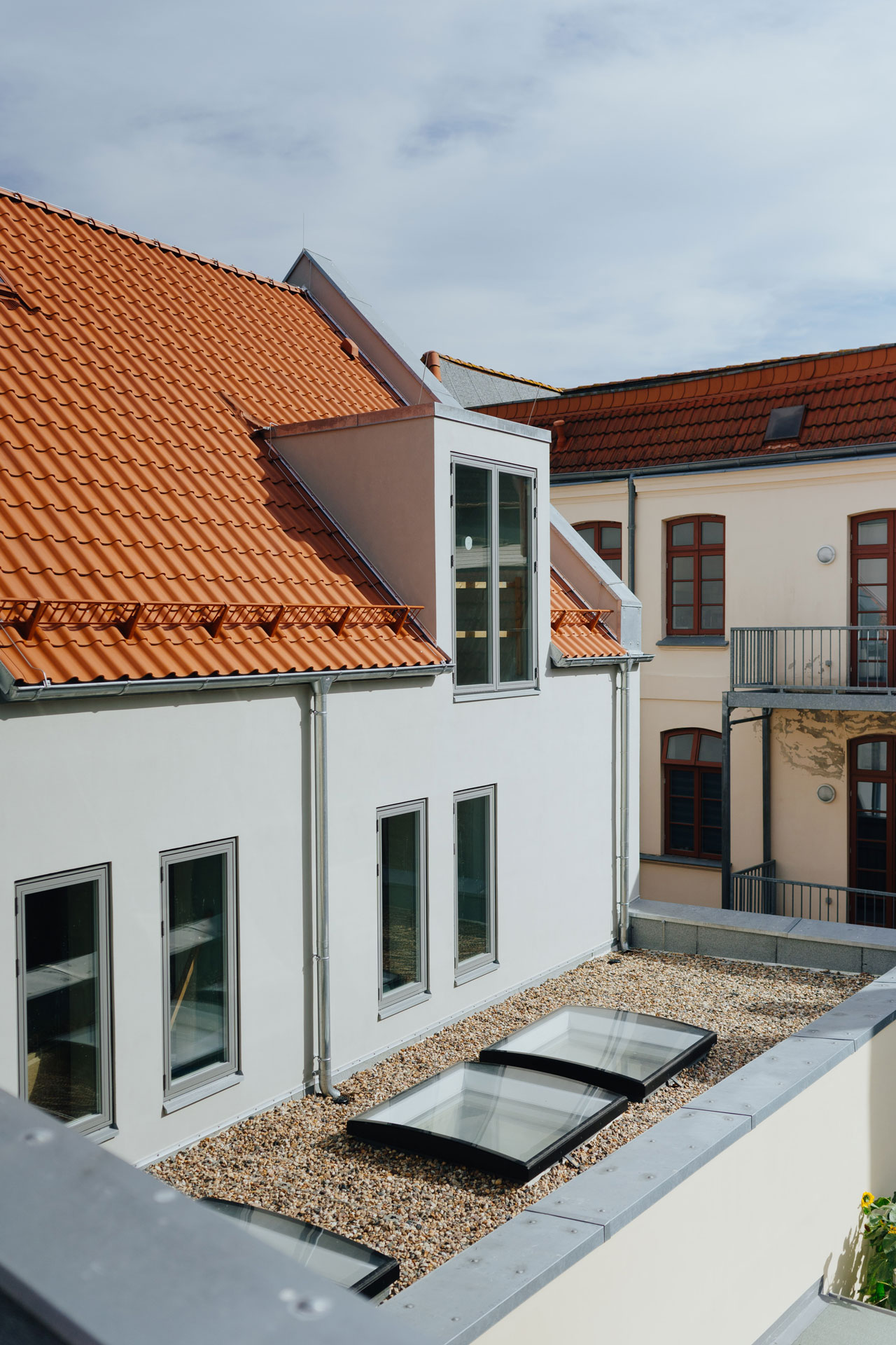 Der Blick auf einen Dachbereich zeigt drei Dachfenster.