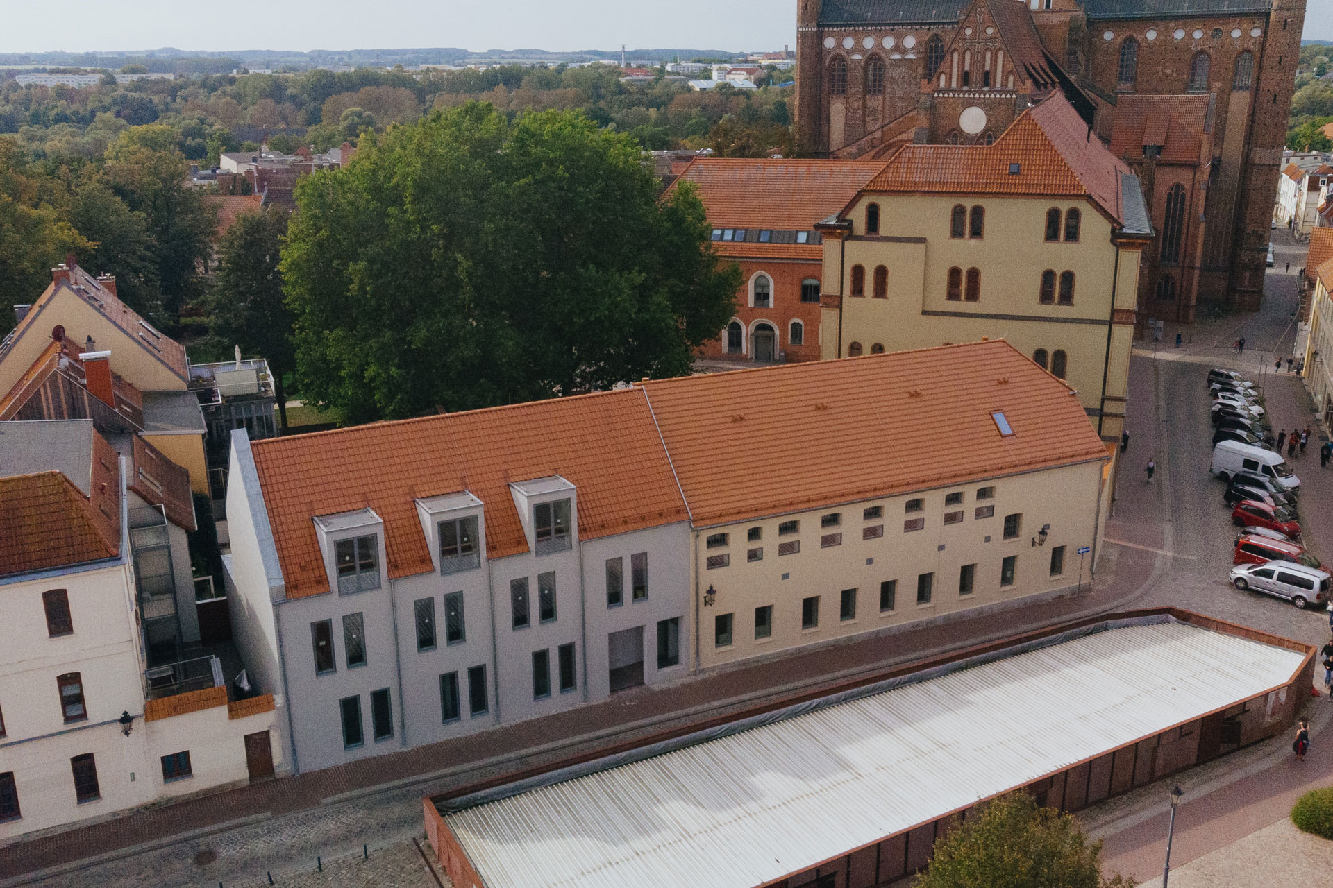 Die Vorderseite der Beherbergungsstätte hat zahlreiche Fenster. Ein Blick über Dächer der Altstadt von Wismar reicht weit in die Ferne.