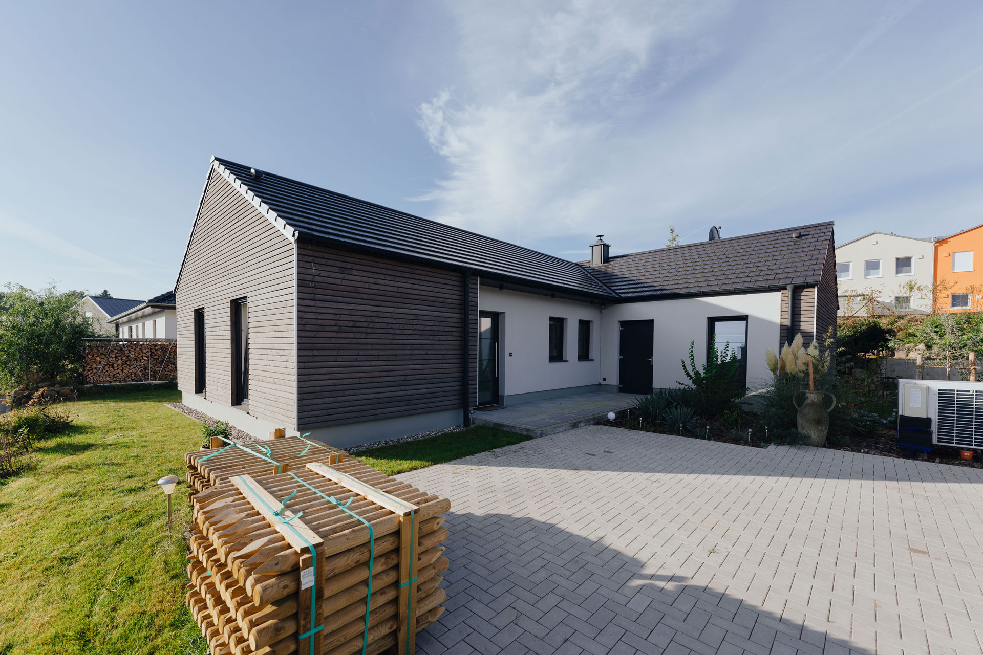 Ein Einfamilienhaus geht über Eck. Einige Bereiche sind mit Holz verkleidet.