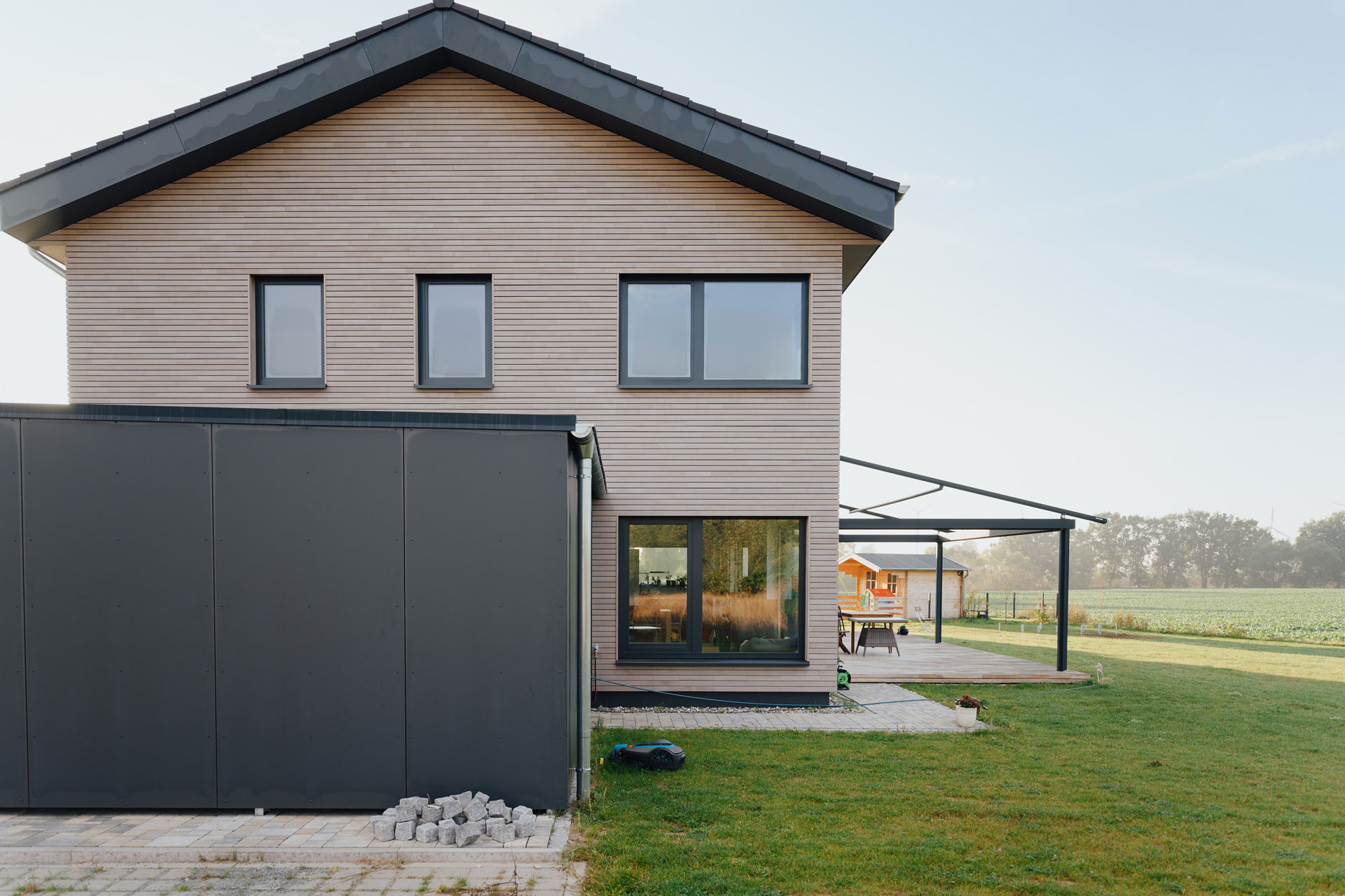 Einfamilienhaus mit Garagenanbau hat eine große Rasenfläche.