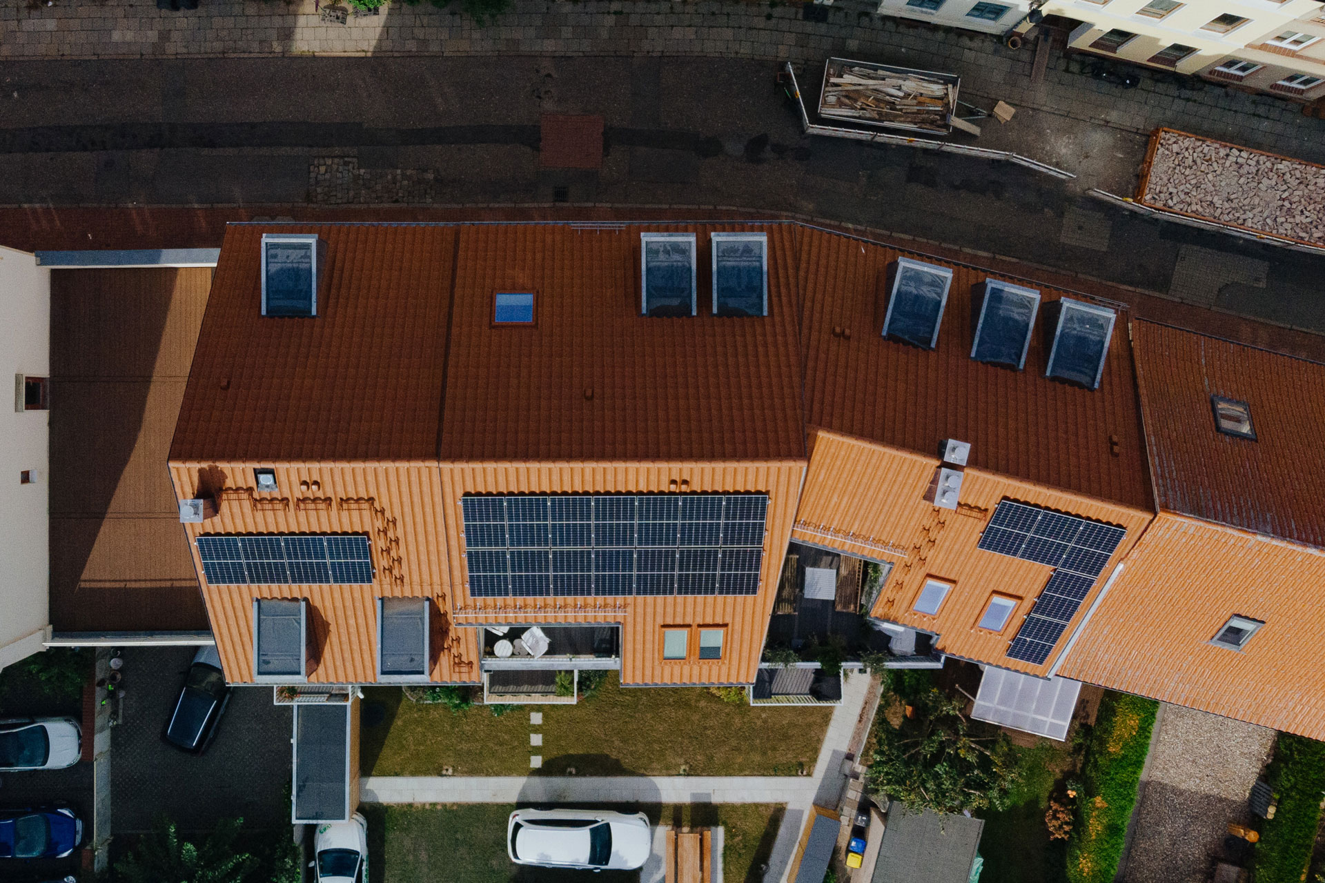 Auf einem roten Ziegeldach ist eine Solaranlage. Man blickt über die Dächer der Altstadt von Wismar.